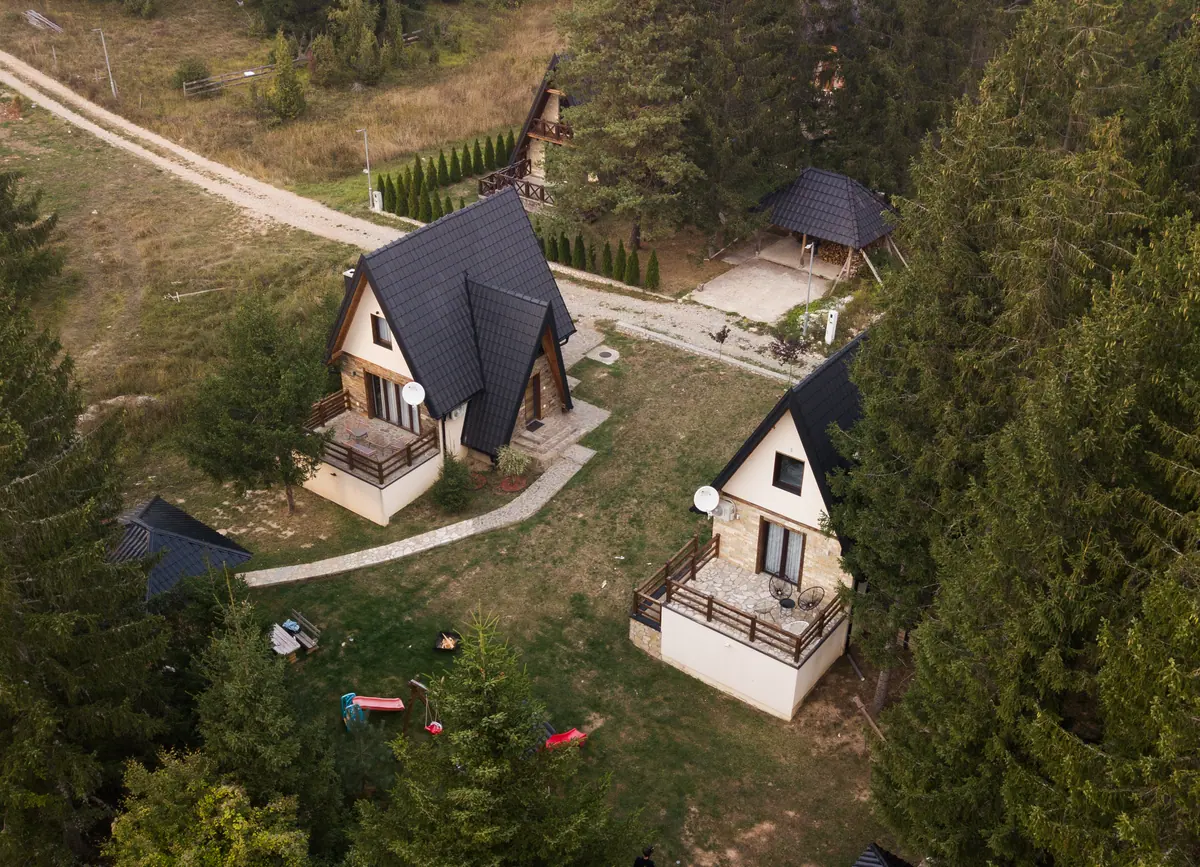 Pogled iz vazduha na kućice usred šume