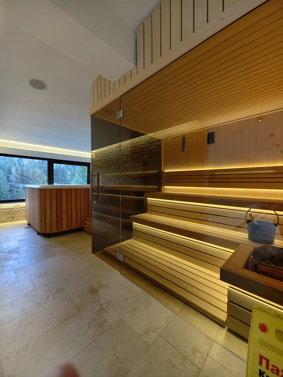 Drvena sauna sa ambijentalnim svetlom i đakuzi uz prozor